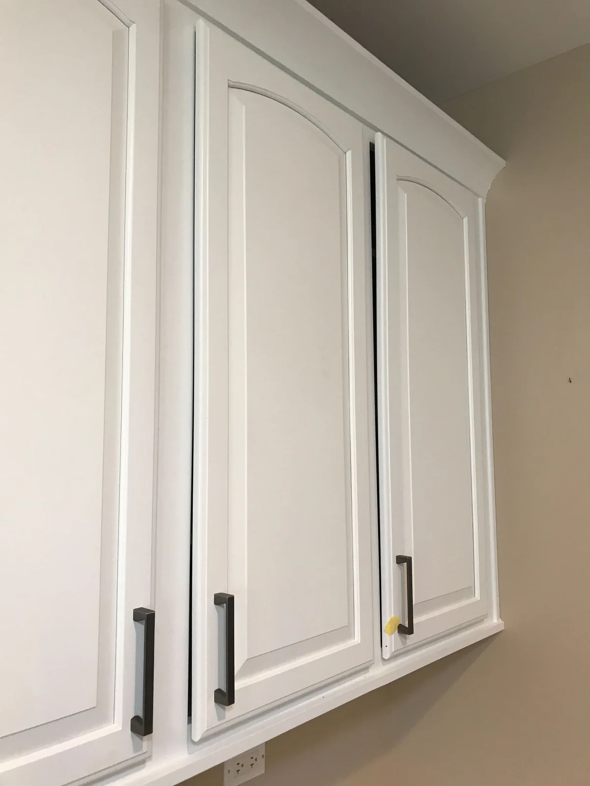 Refinished white upper cabinets with black hardware