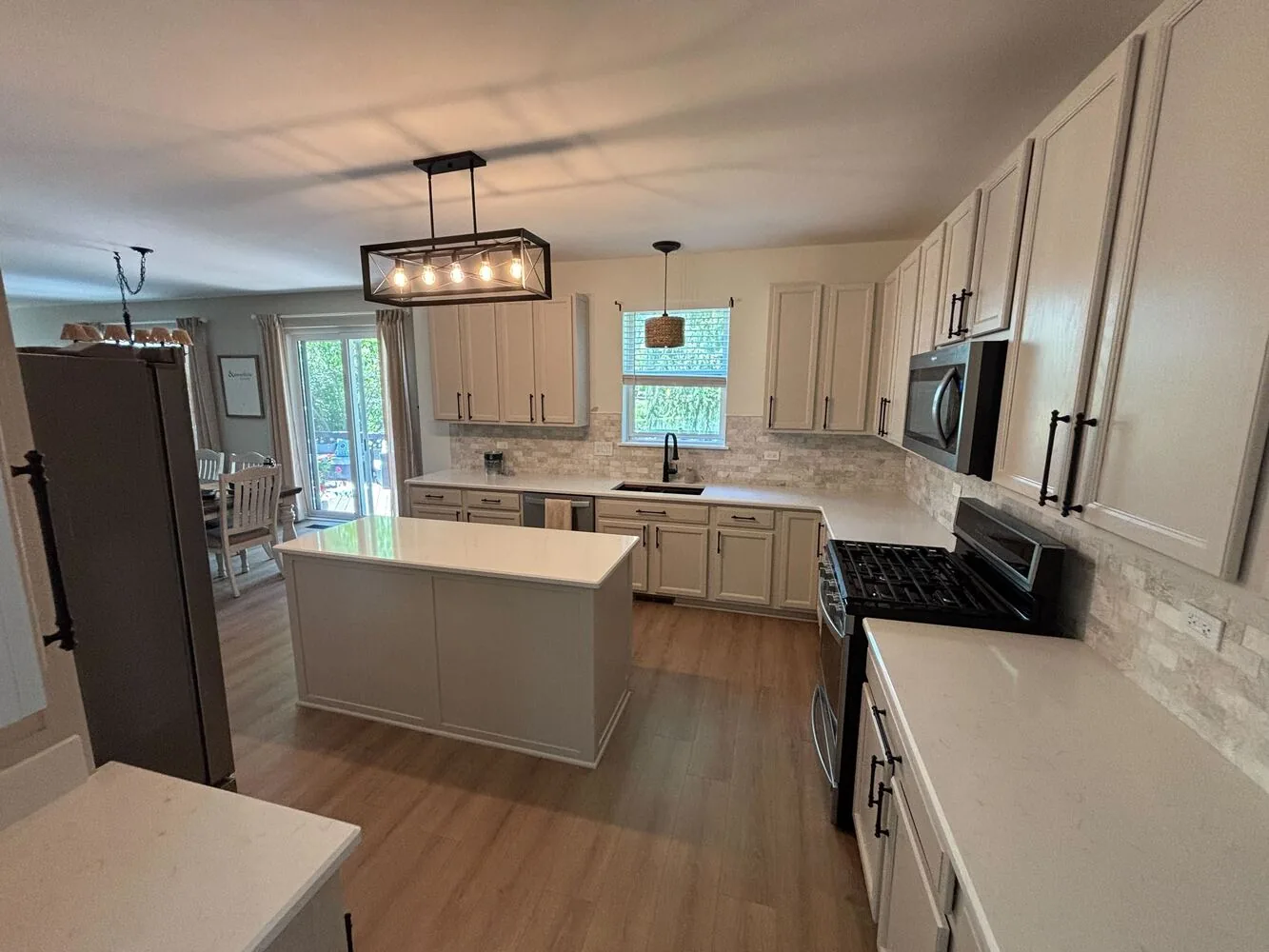 White refinished cabinets and island with black hardware