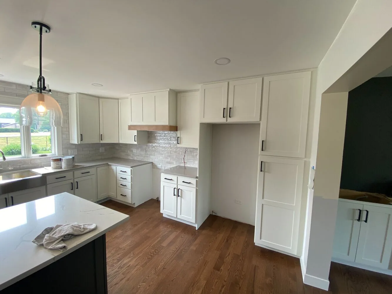 White refinished cabinets with a wood range hood