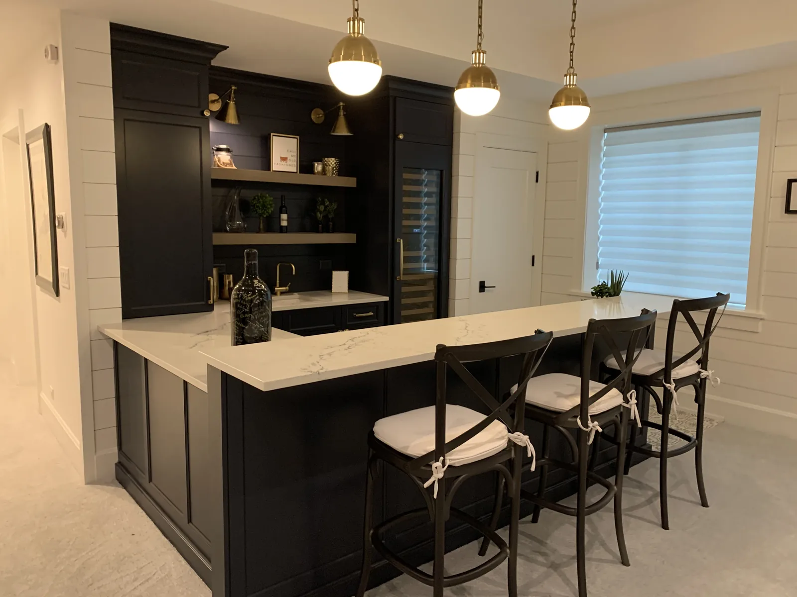 Black refinished bar cabinets with brass pendants