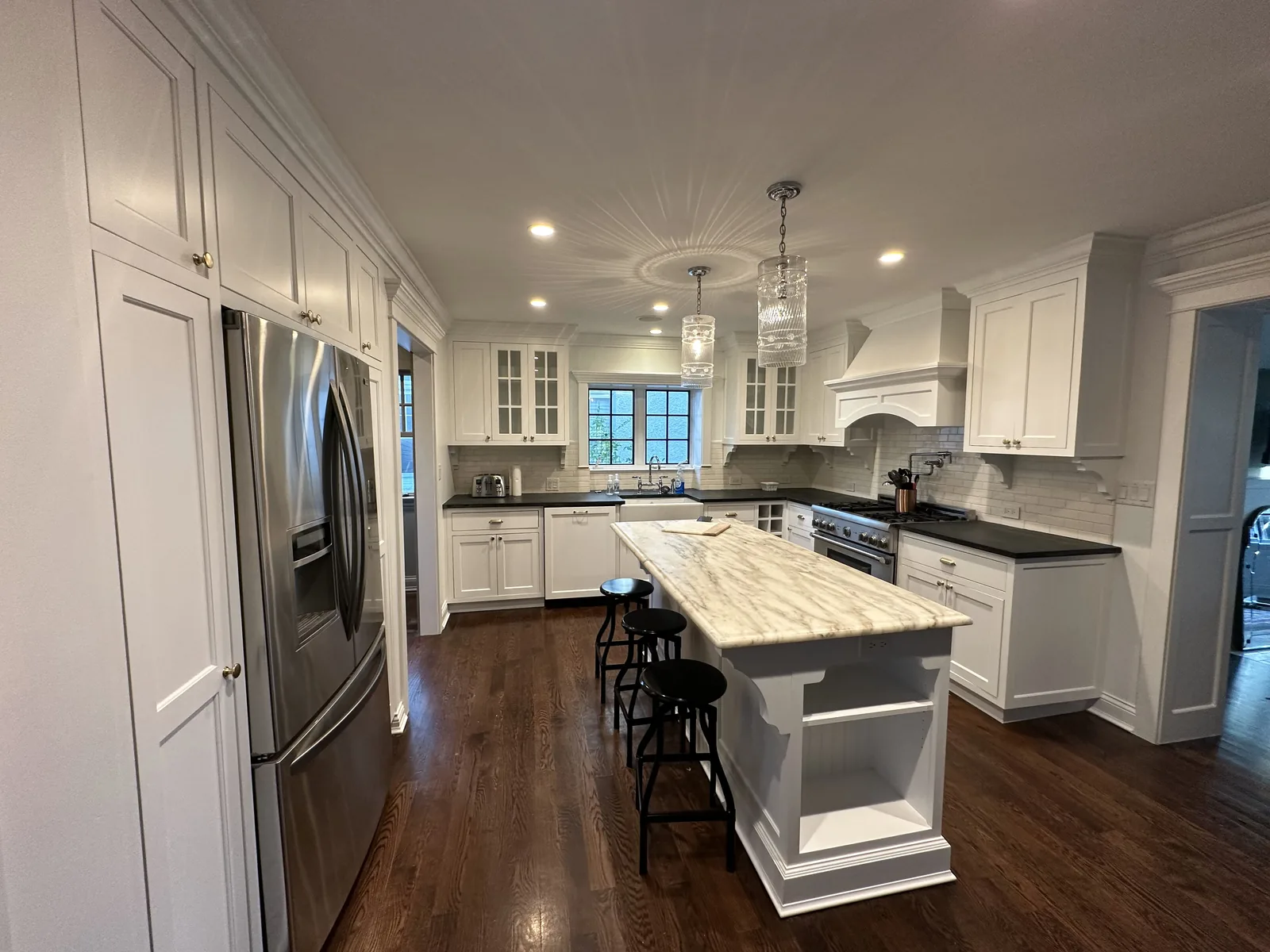 White refinished cabinets with a marble island