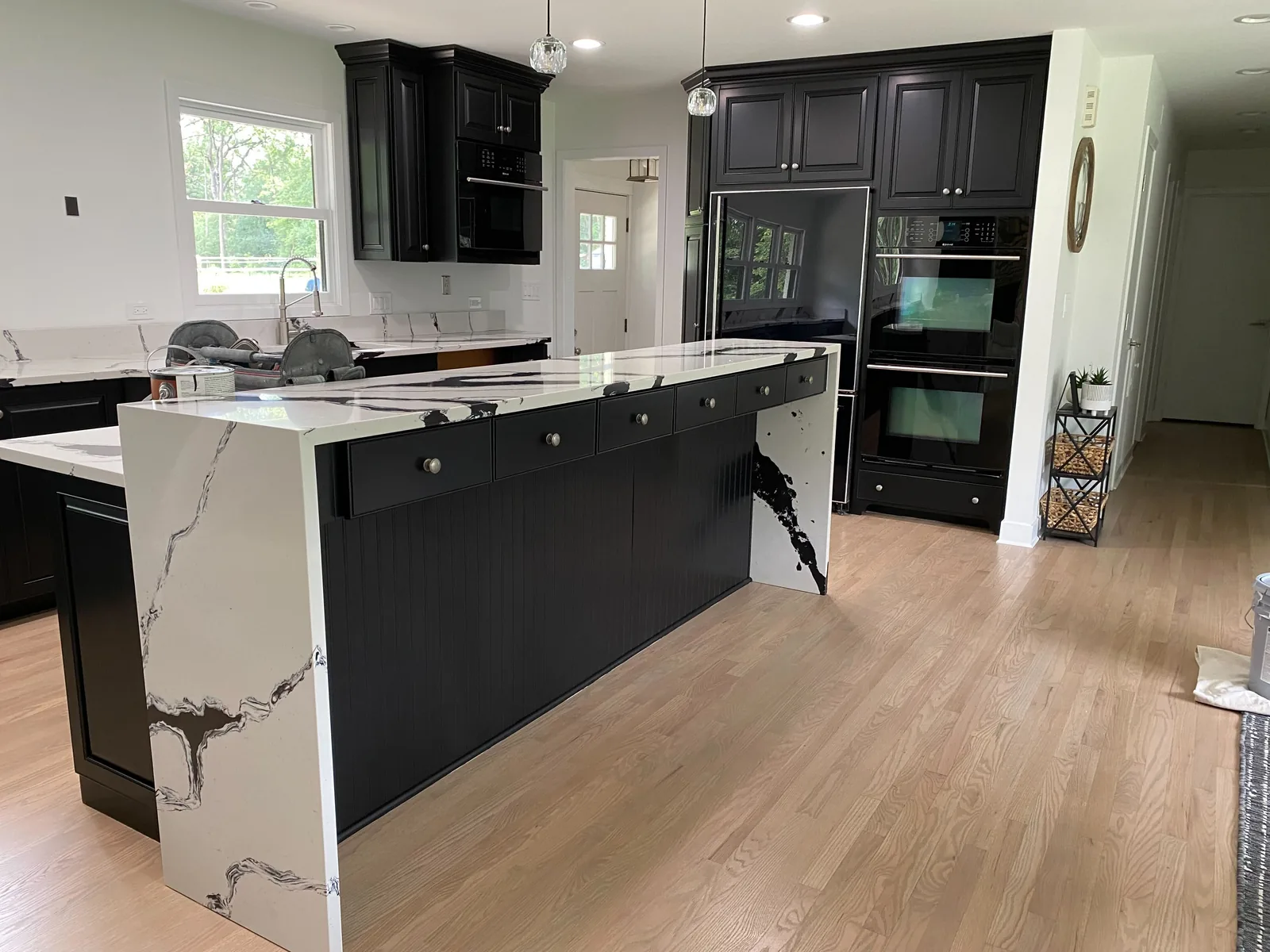 Black refinished cabinets with a waterfall marble island