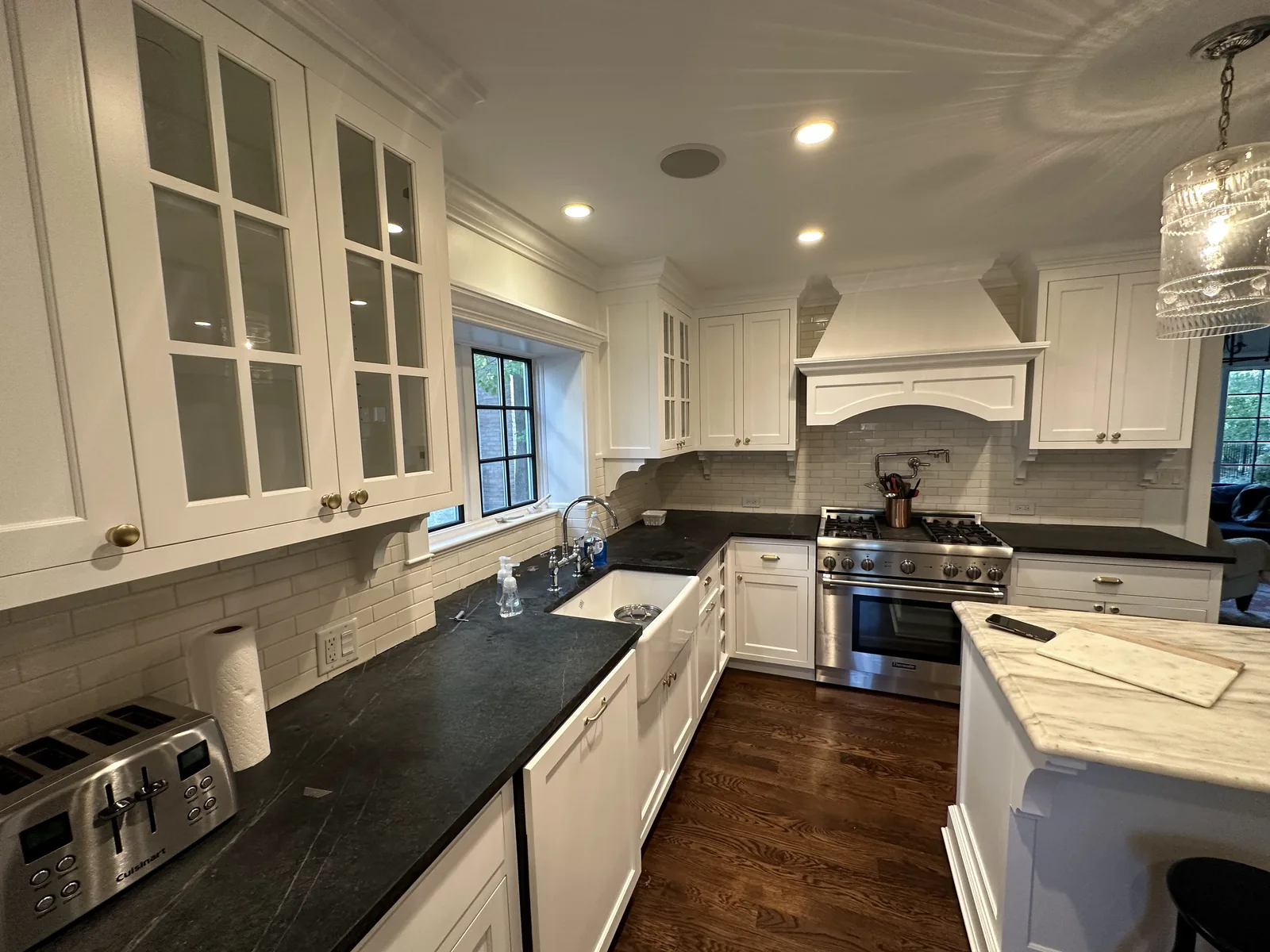 White refinished cabinets with a black countertop and glass uppers