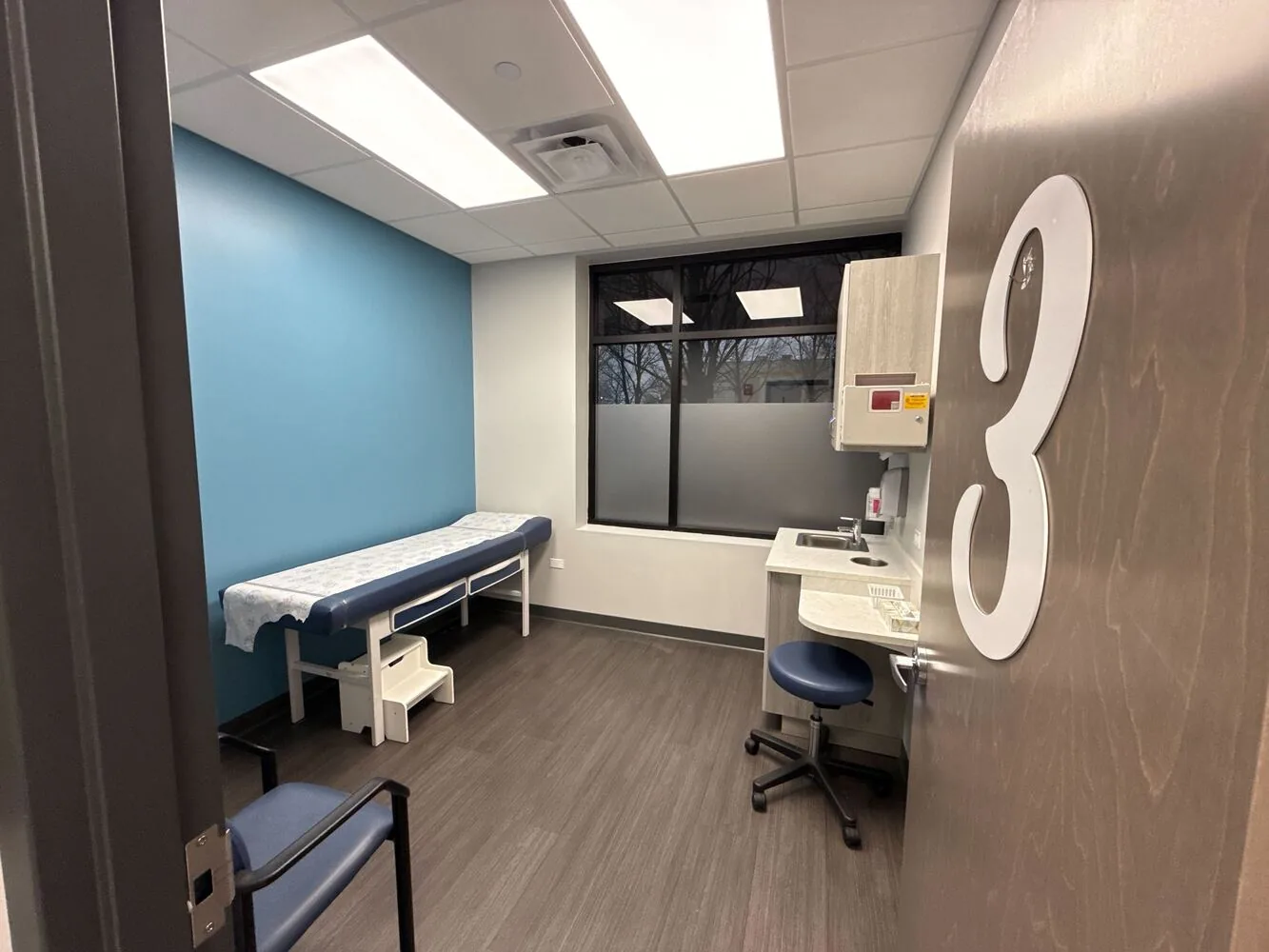 Repainted medical exam room with a blue accent wall