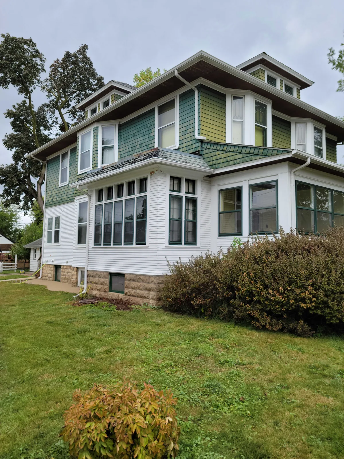 Green and white four square home after an exterior repaint