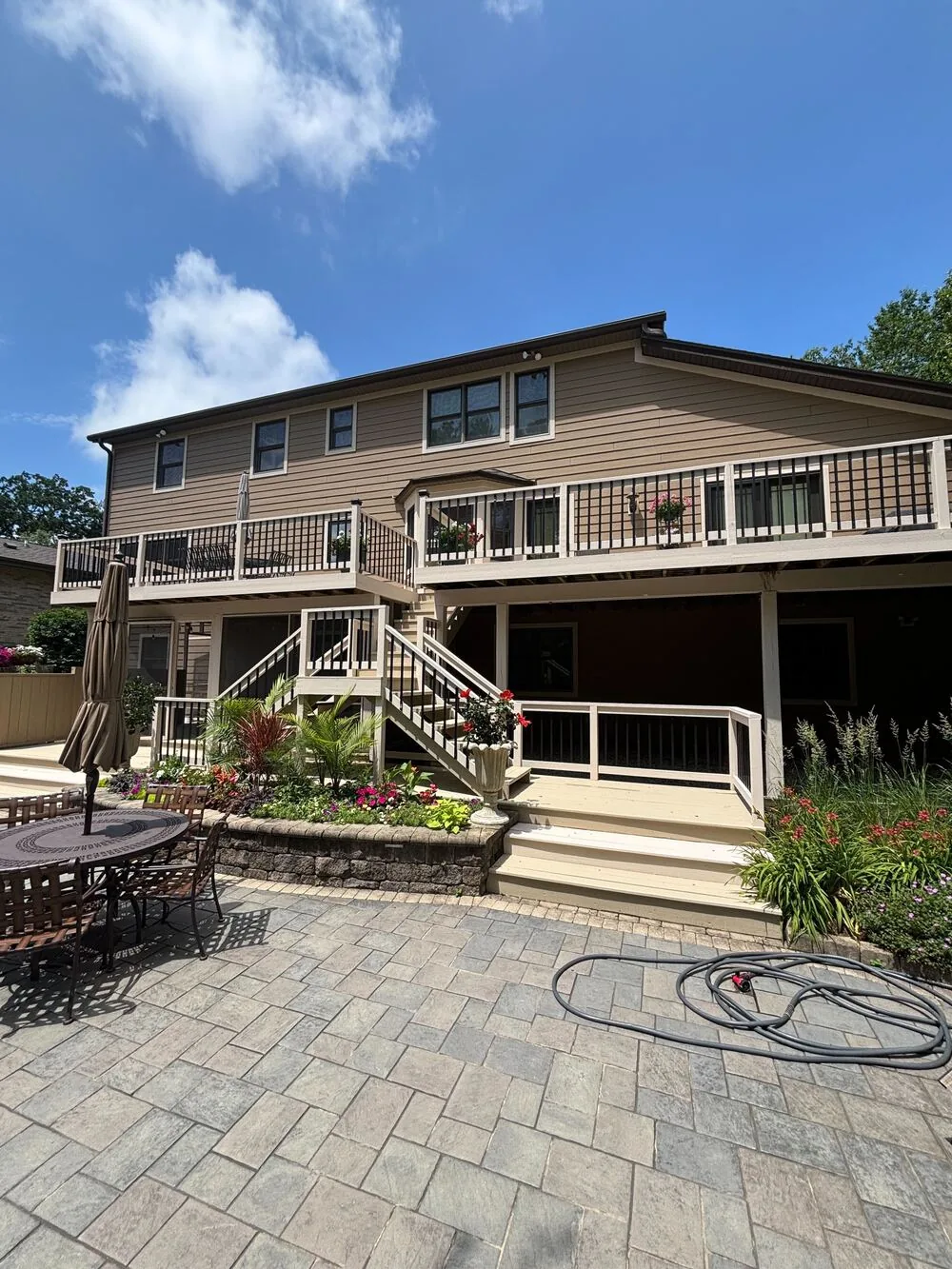 Repainted rear elevation with a two level deck and patio