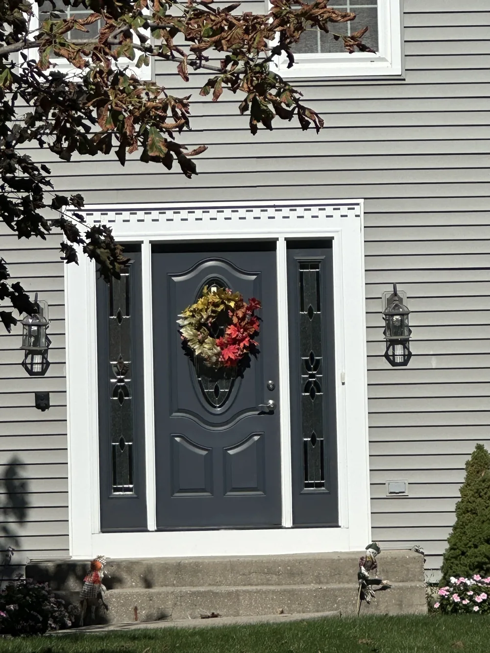 Charcoal front door with white trim on gray siding