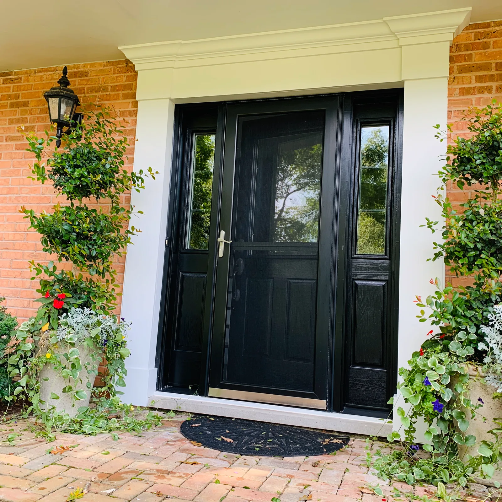 Black front door with a white surround on a brick home