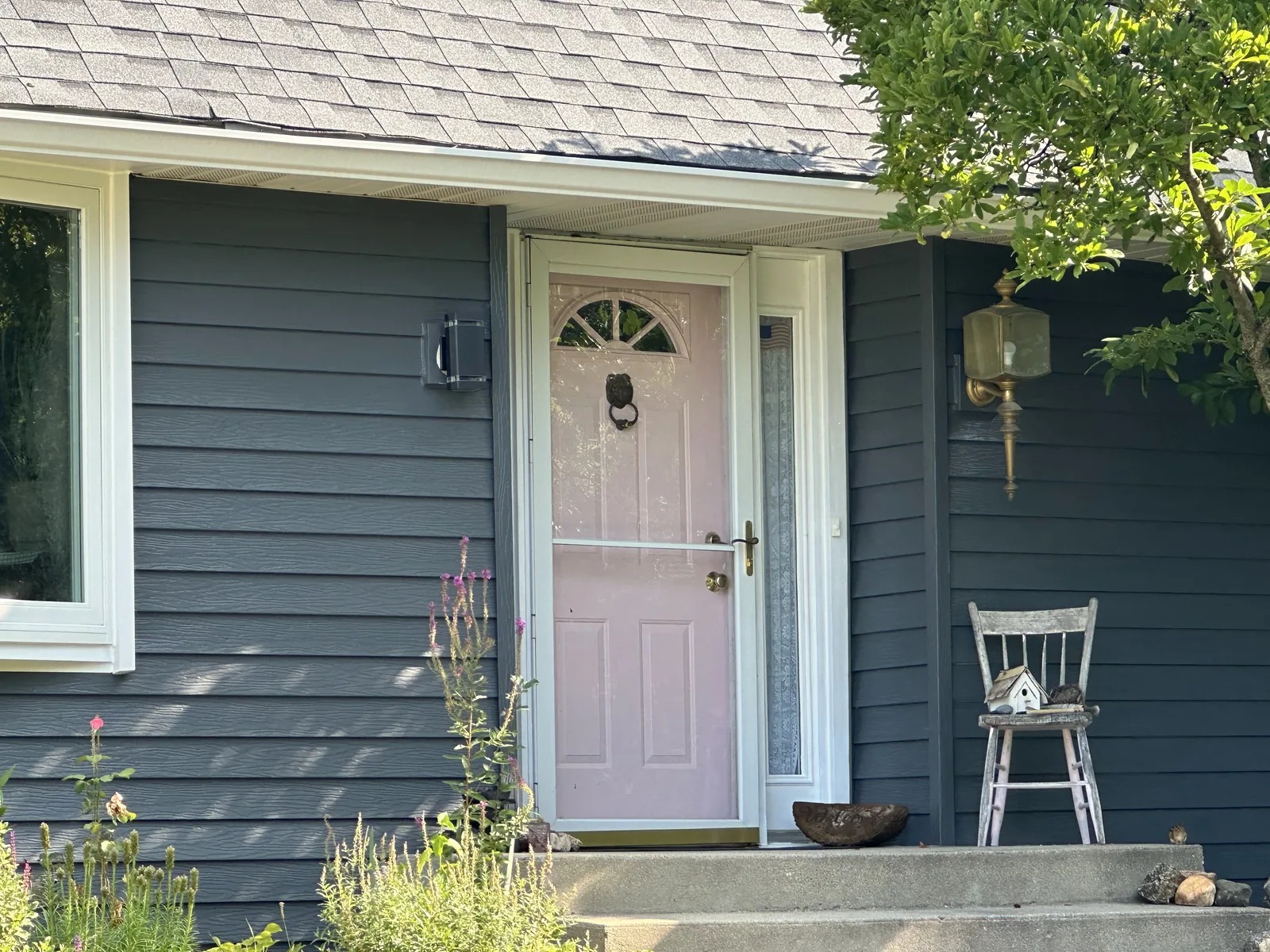 Navy siding and a blush front door after an exterior repaint