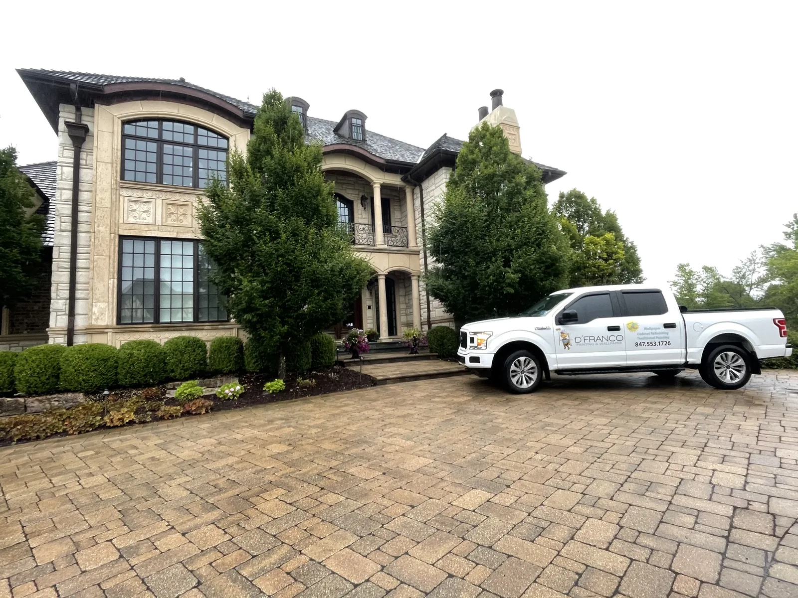 D'Franco truck in front of a stone home with a paver driveway