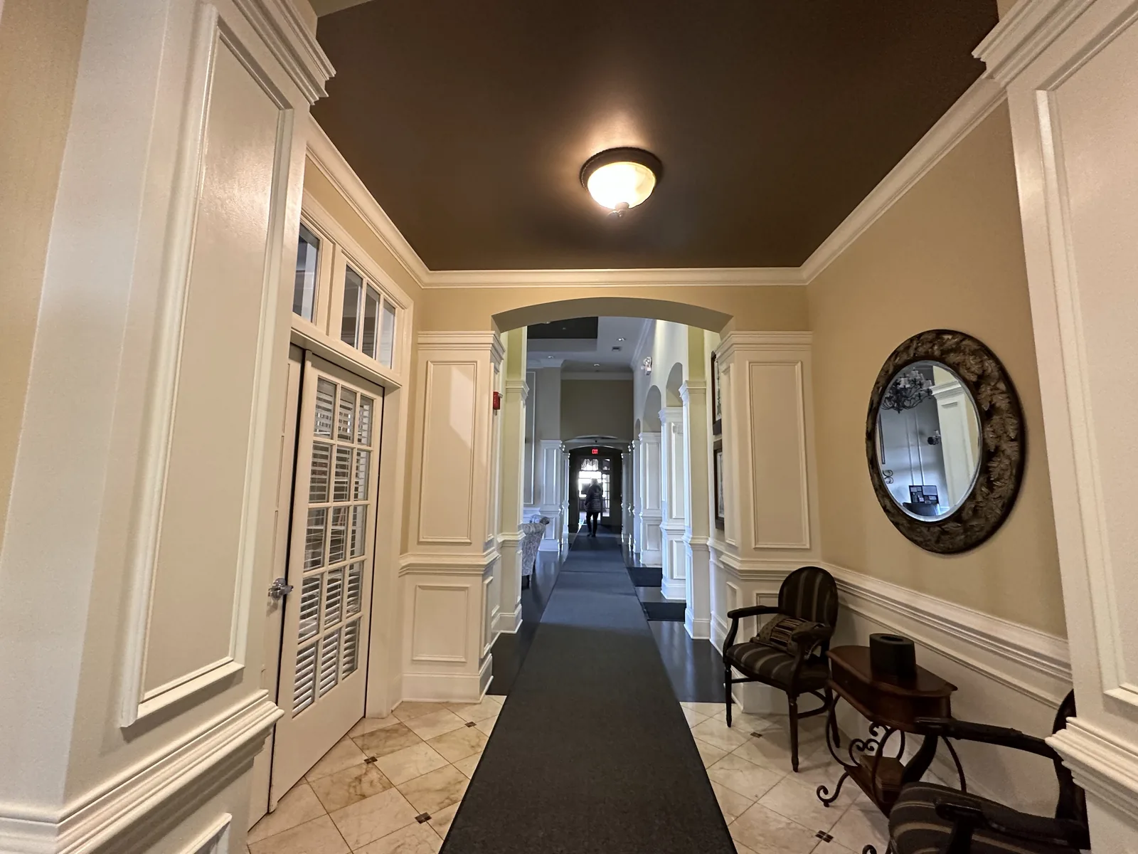 Hallway with a chocolate ceiling, cream walls and white trim