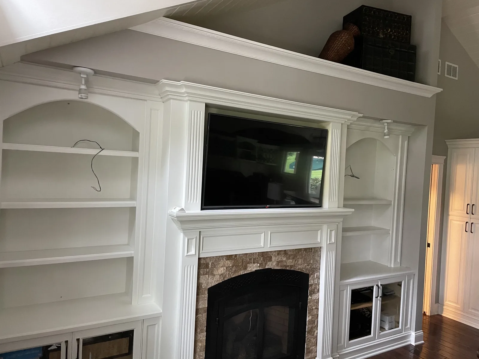 White built ins and mantel around a stone fireplace