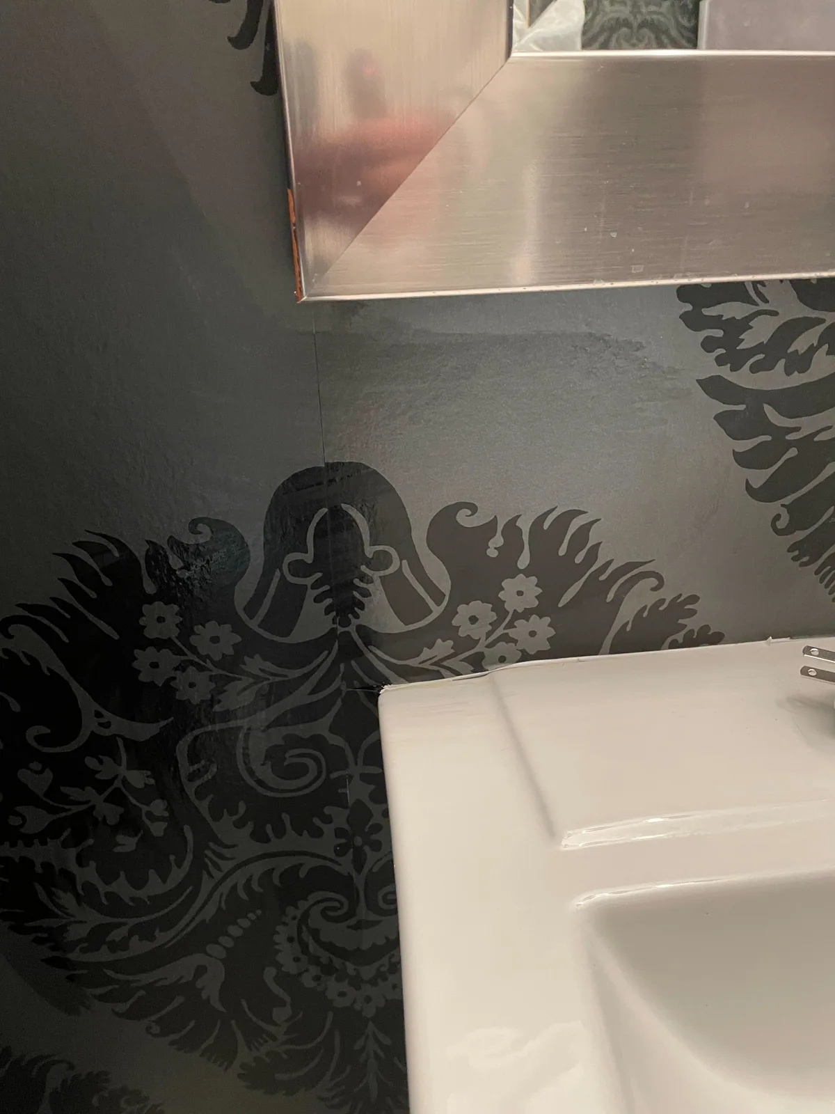 Dark damask wallpaper installed in a bathroom