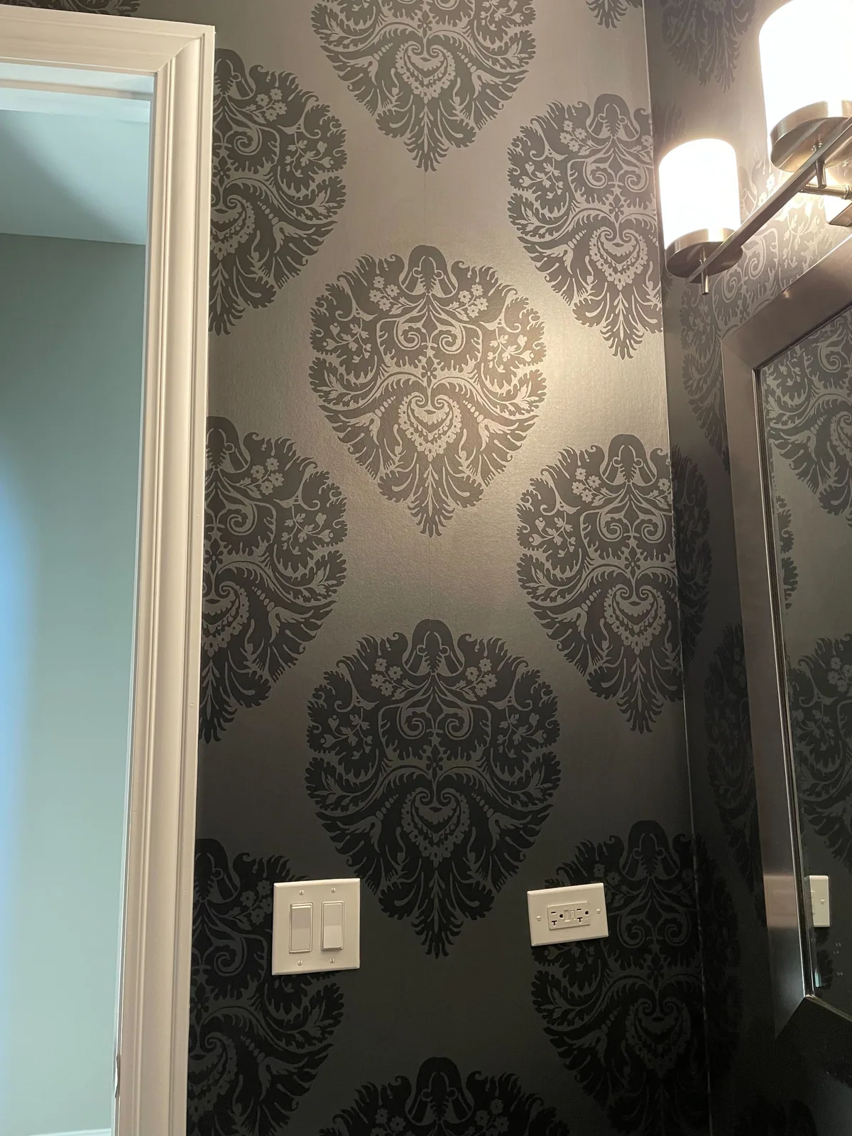 Gray damask wallpaper in a powder room