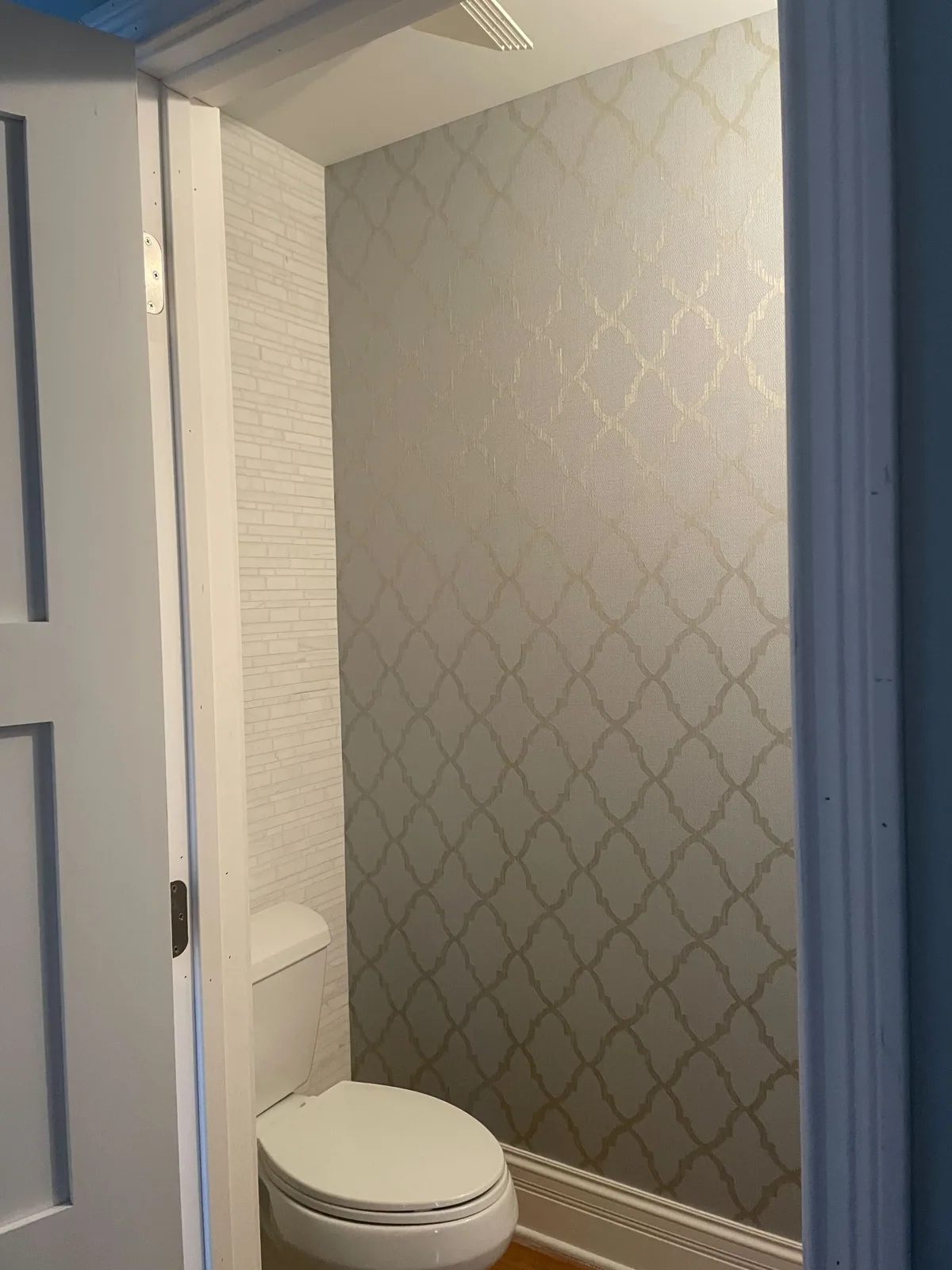 Soft trellis pattern wallpaper in a powder room