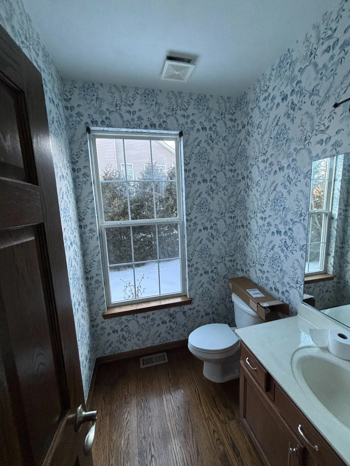 Blue floral wallpaper around a bathroom window