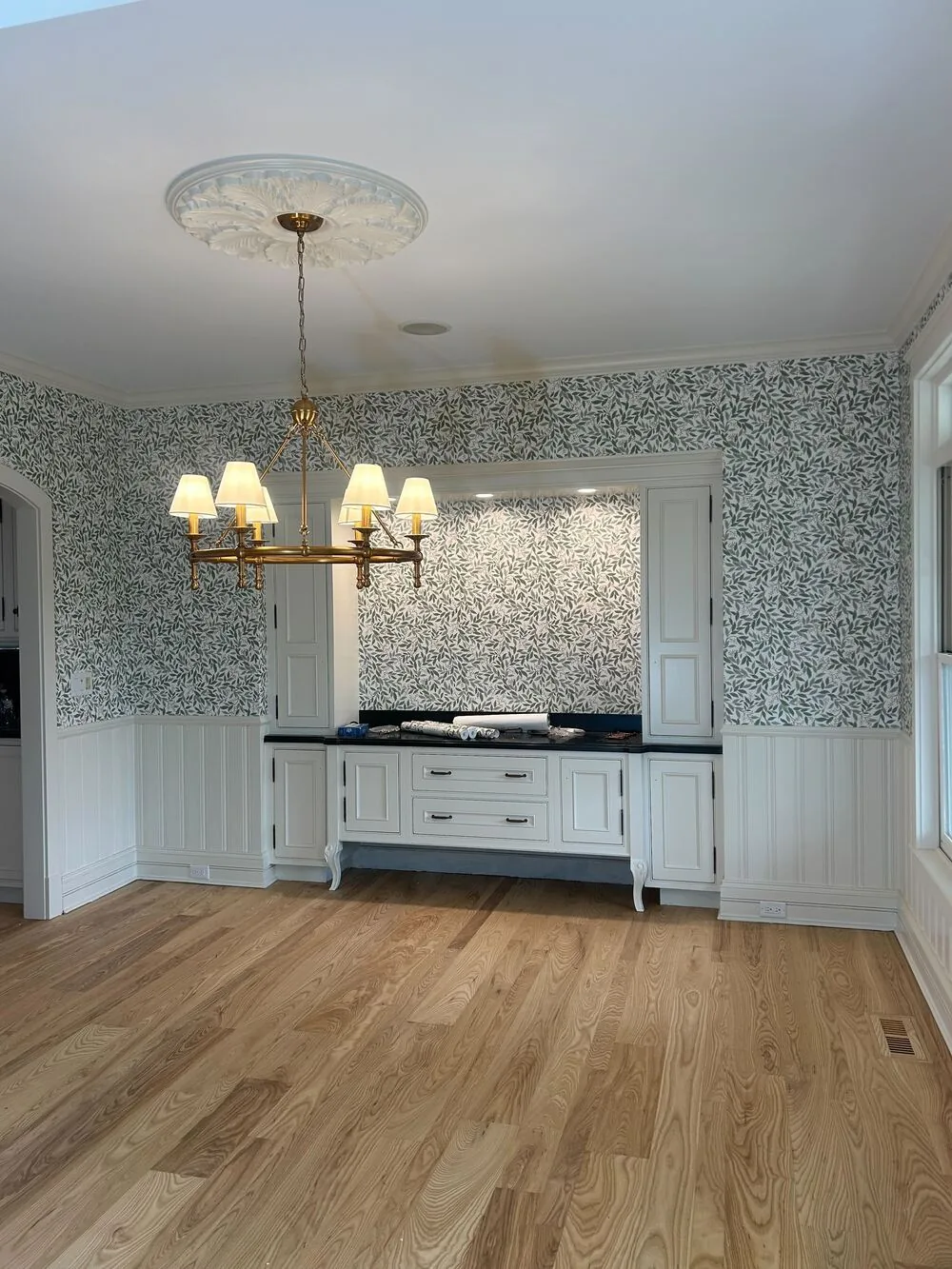 Blue botanical wallpaper in a dining room with wainscoting