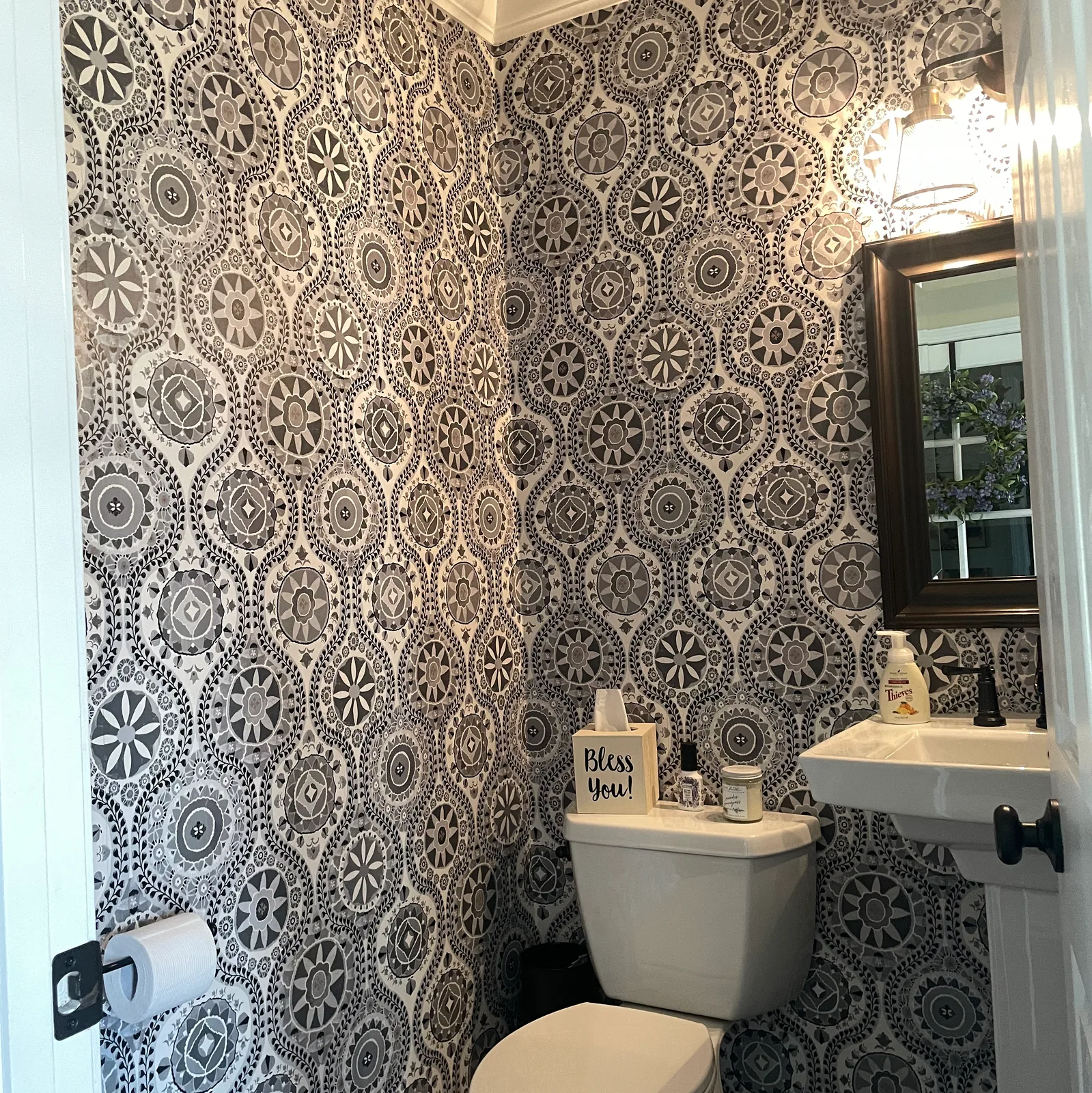 Black and white medallion wallpaper in a powder room