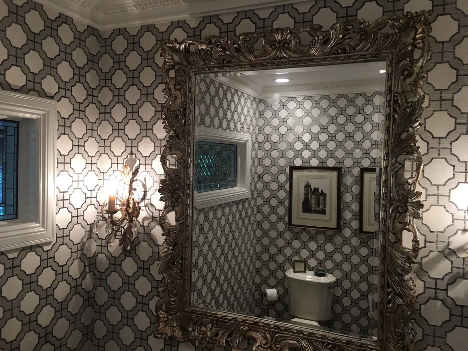 Geometric wallpaper around a powder room mirror